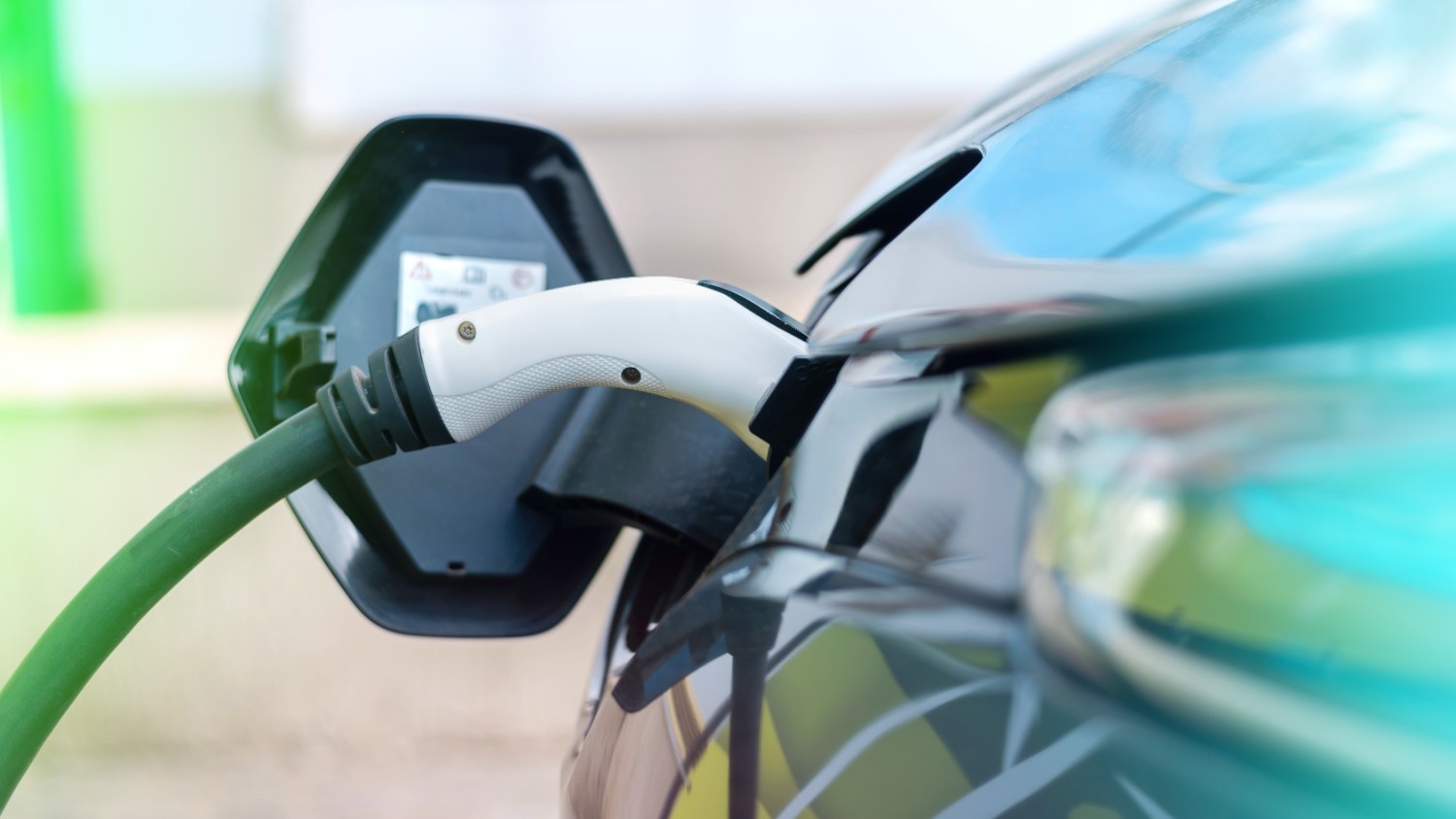 Electric vehicle charging at a power station using a Level 2 connector, representing modern EV charging infrastructure.