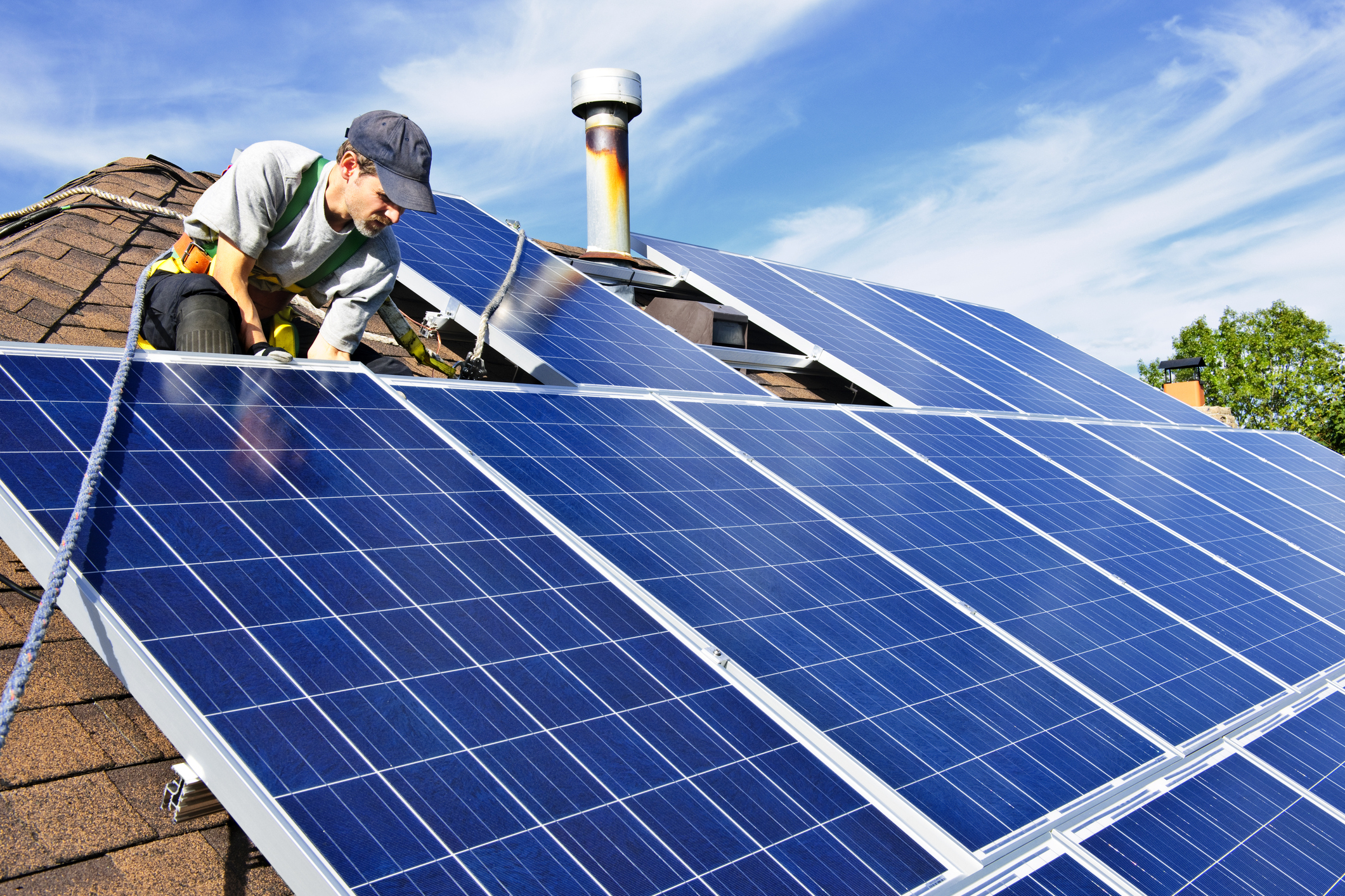Technician installing rooftop solar panels, representing energy-efficient solar power solutions and industry expertise.